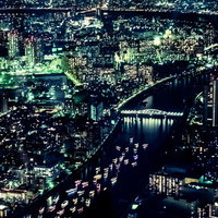 川を流れるカラフルにライトアップされた屋形船と都会の夜景の写真