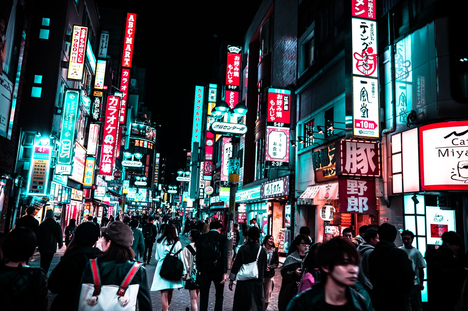 色とりどりのネオンサインが輝く夜の渋谷センター街を歩く大勢の通行人