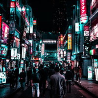 渋谷駅方向へ向かう路地裏のネオン街を歩く人の群れの写真