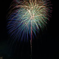 夏の花火大会で同時打ち上げの光跡の写真