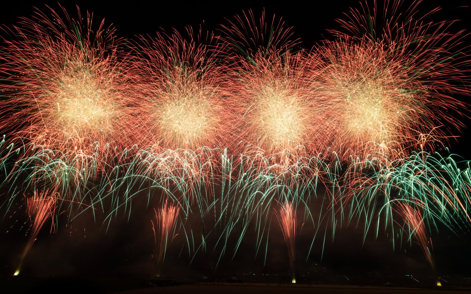 夜空に打ち上げられた色とりどりの花火が光の軌跡を描く様子