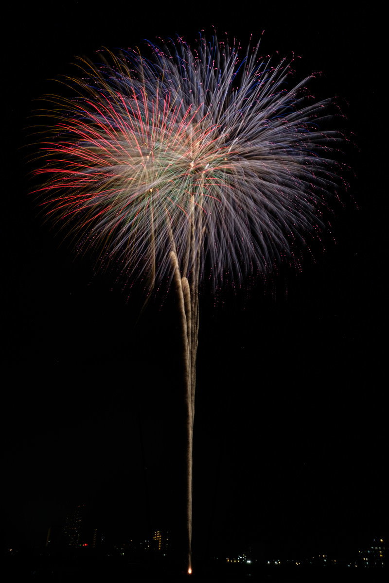 夜空に大きく咲いた打上げ花火の光の軌跡