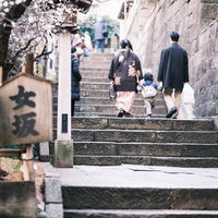 湯島天神の女坂をのぼる親子の後ろ姿と参道風景の写真
