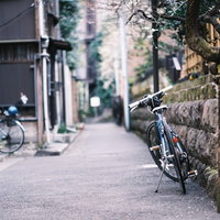 住宅街の石畳の路地に停めた自転車の写真