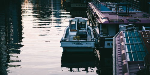 夕暮れ時の神田川に係留された釣り船と屋形船