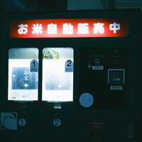 街角に設置されたお米の自動販売機の夜間営業風景の写真