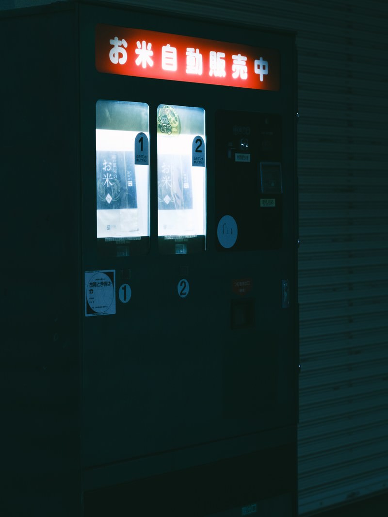 暗闇の中で赤い看板が光るお米の自動販売機