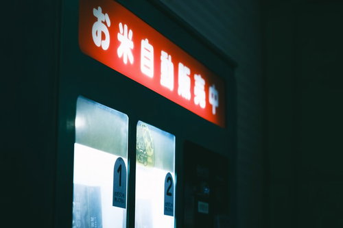 恍惚と点灯したお米自動販売機の照明と商品展示