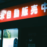 夜間営業のお米販売中を知らせる赤い看板の写真