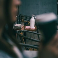 喫茶店入口に設置された消毒剤ボトルと衛生管理用品の写真