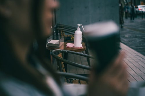 喫茶店入口に設置された消毒剤ボトルと衛生管理用品