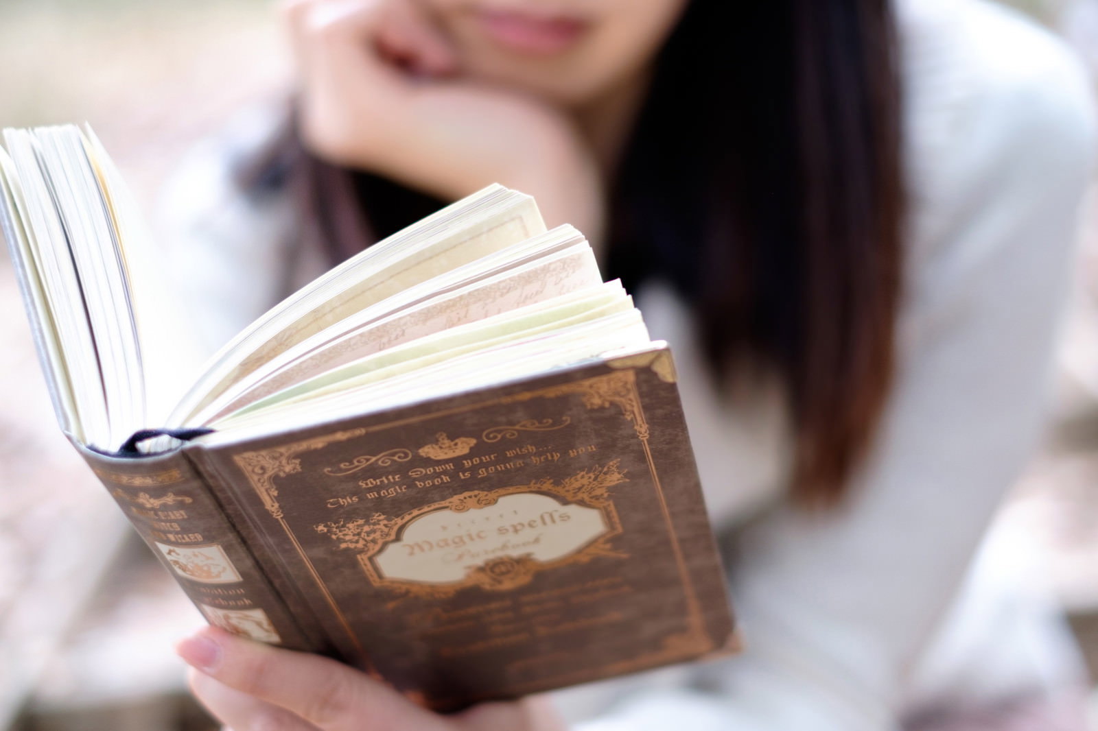 洋書を手に持って読書している女性