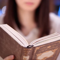 カフェで洋書を読む女性の読書風景の写真