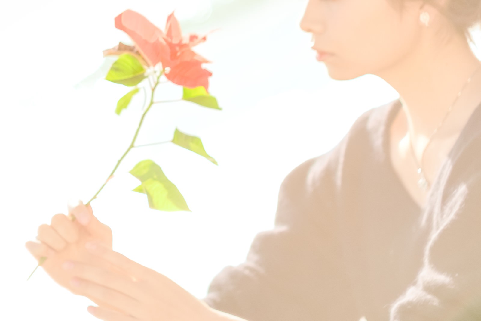 白い服を着た女性が小さな花を手に持っている