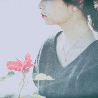 ピンクの花を握るセンチメンタルな気分の女性の写真