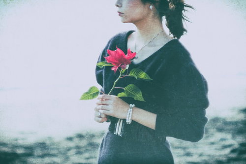 赤い薔薇を手にした暗い悲しみの女性の失恋