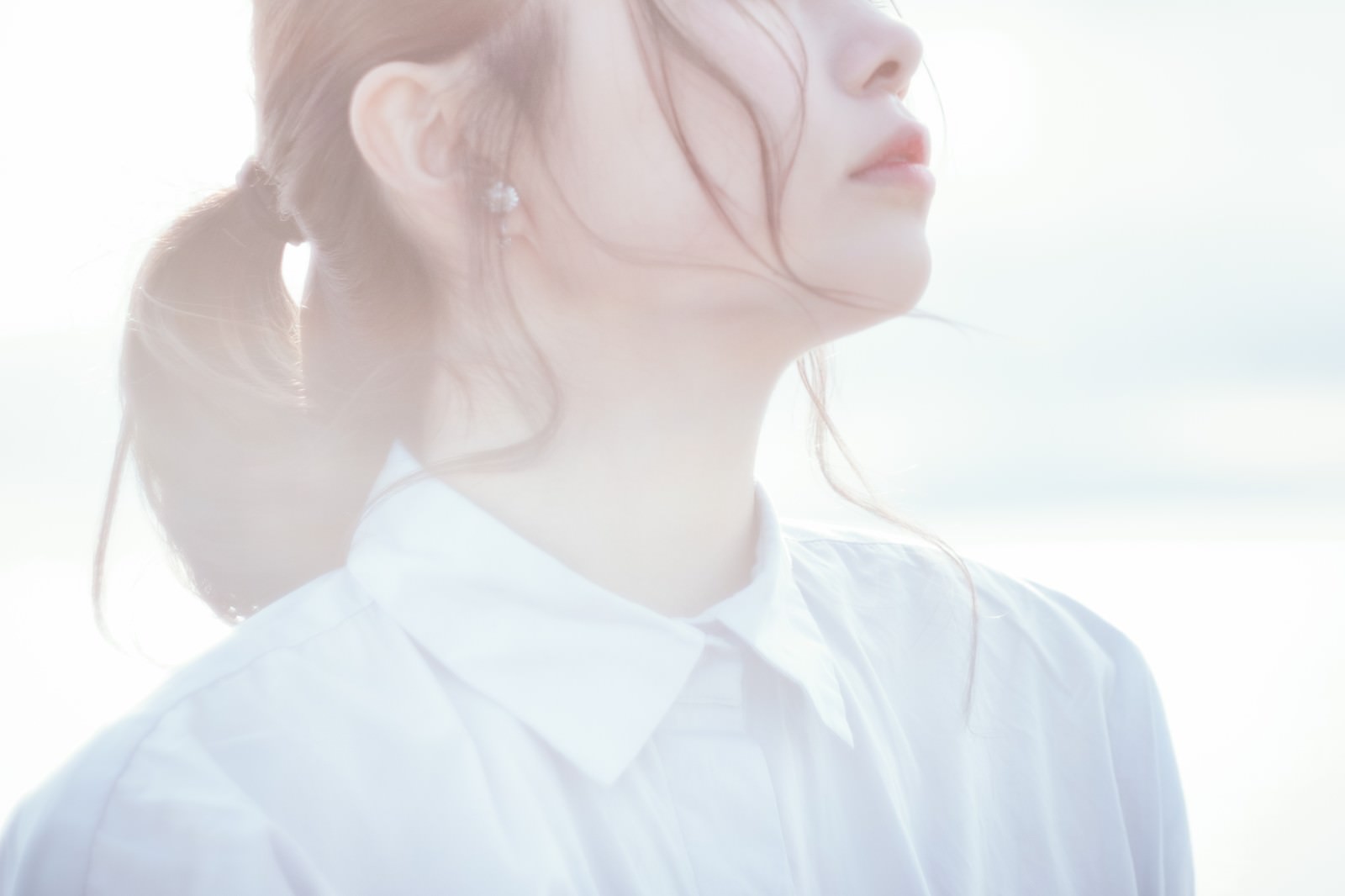 逆光の中で横を向く若い女性の横顔