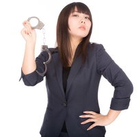 手錠を掲げる高圧的な女性弁護士、法廷での厳格な態度を表現の写真