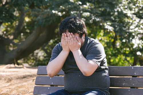 悩みを抱える男性が公園のベンチで絶望した様子