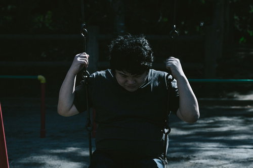 ブランコで絶望する男性の失敗と後悔の瞬間