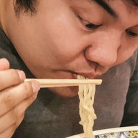 ラーメンを食べている男性の食事風景の写真