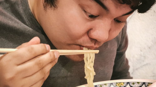 ラーメンを食べている男性の食事風景