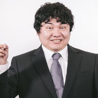 ビジネスマンが右手で上方を指して案内するポーズの写真