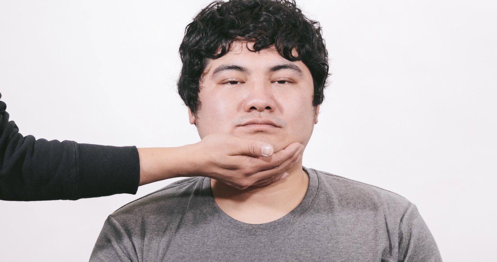 アゴをタプタプさせた虚ろな表情の男性［モデル：段田隼人］