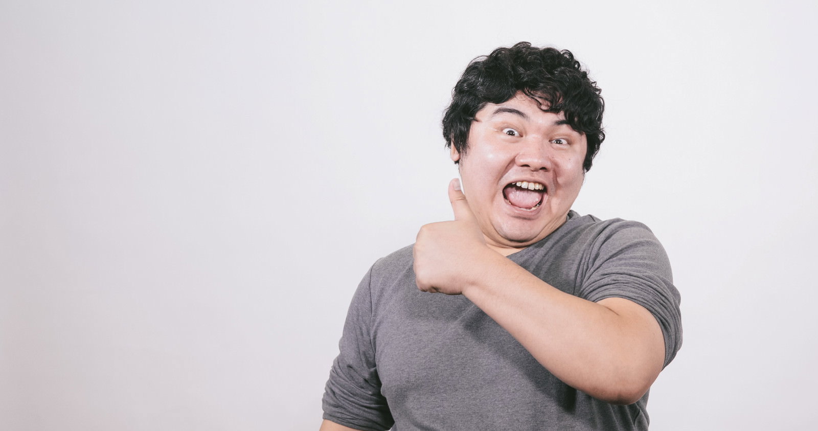 親指を立てて笑顔のサムズアップ男性［モデル：段田隼人］