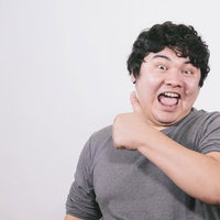 親指を立ててサムズアップして喜ぶ男性のポートレートの写真