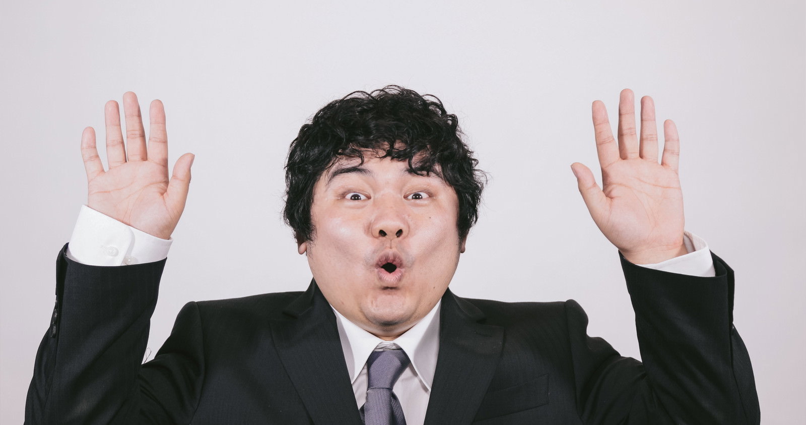 あっと驚くビジネスマンの両手上げジェスチャーの写真素材 - フリー