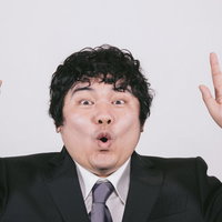 あっと驚くビジネスマンの両手上げジェスチャーの写真