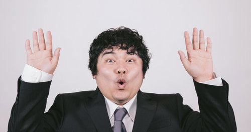 あっと驚くビジネスマンの両手上げジェスチャー
