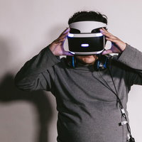 VRヘッドセットを装着して操作する男性のゲーム体験の写真