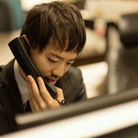 クライアントとの電話対応をするビジネスマンの写真