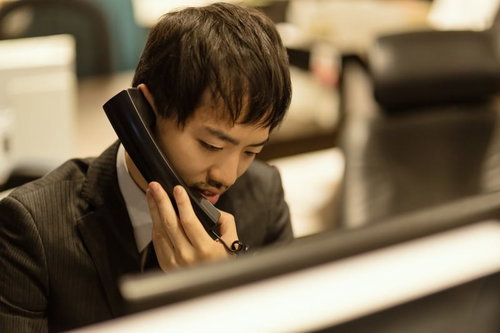 クライアントとの電話対応をするビジネスマン