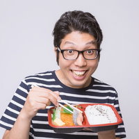 笑顔でお弁当を食べる眼鏡の男性の写真