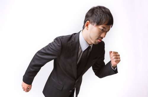 前のめりで走り出すサラリーマン