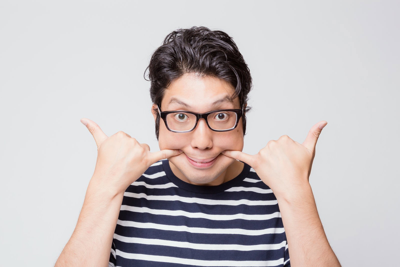 両手を頬に当てておどけた表情で笑う、眼鏡をかけた男性［モデル：紳さん］
