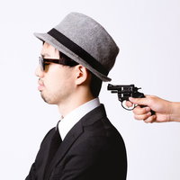 背後から拳銃を突きつけられるエージェントの写真