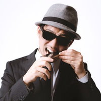 スマホに噛りつくエージェント風の男性の写真