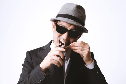 スマホに噛りつくエージェント風の男性