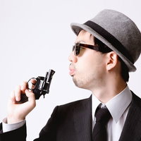 拳銃の硝煙を吹き消すエージェントの写真