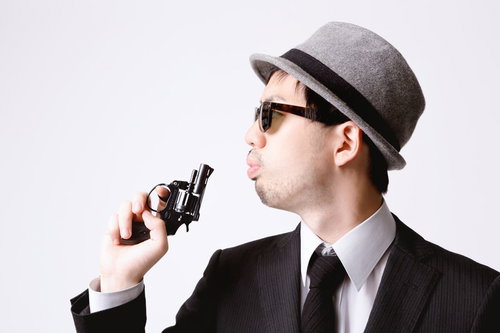 拳銃の硝煙を吹き消すエージェント