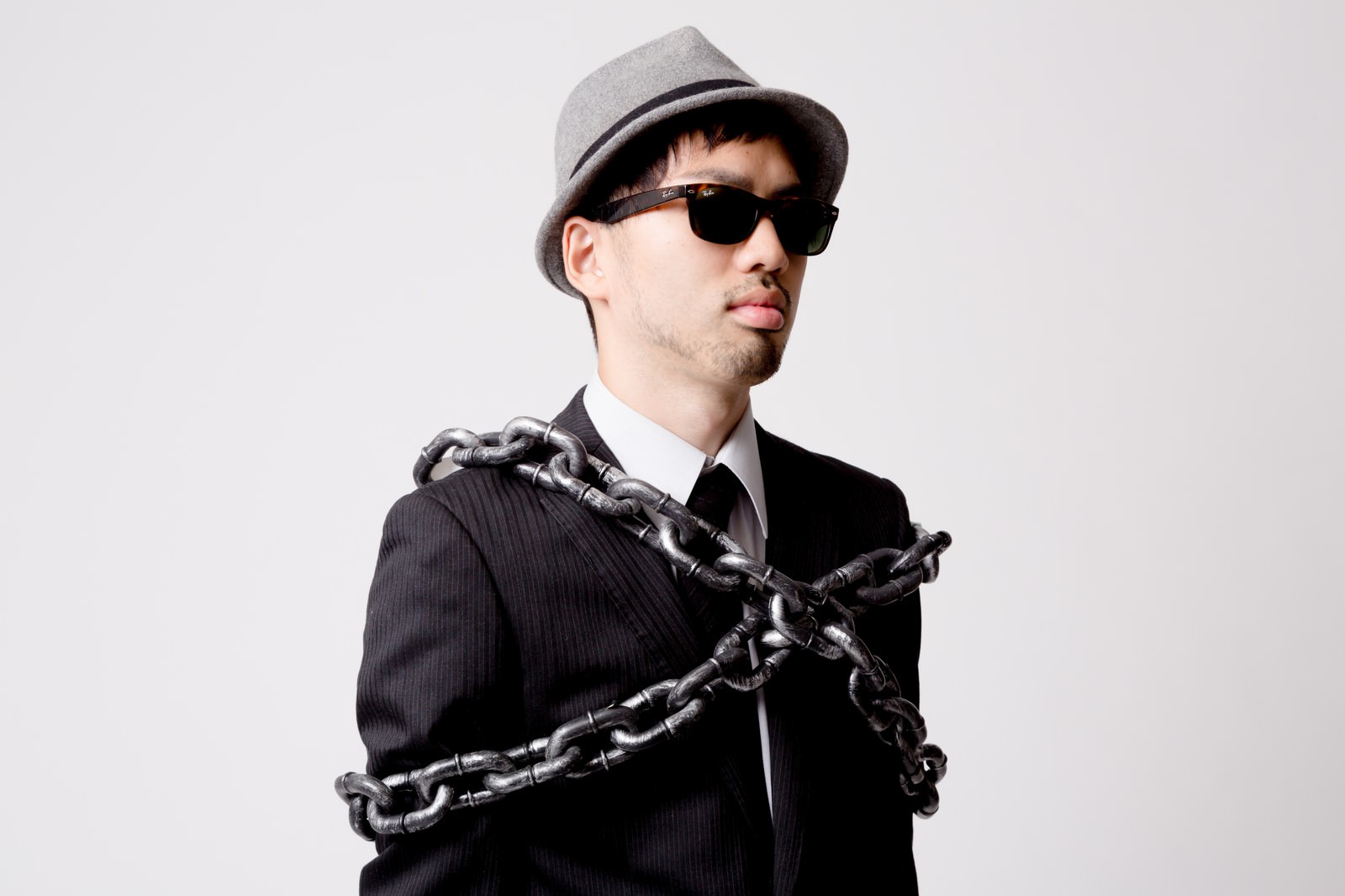 鎖を体に巻き付けられた帽子とサングラスのエージェント［モデル：ひろゆき］