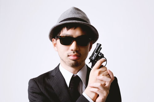 拳銃を顔の横に構えるエージェント