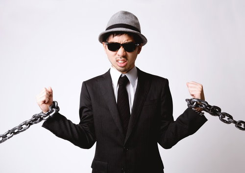 両腕を鎖で拘束されたエージェント