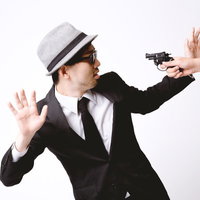 拳銃を突きつけられ両手を上げるエージェントの写真