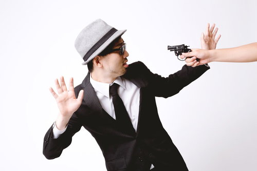 拳銃を突きつけられ両手を上げるエージェント