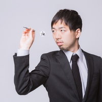 ダーツの矢を構えるスーツ姿のビジネスマンの写真